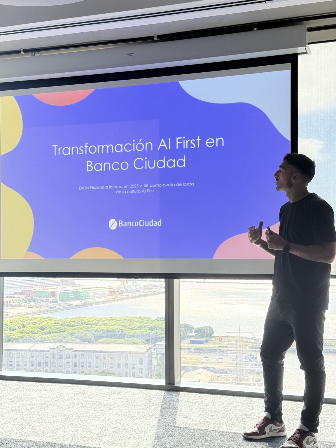 Matias Venutolo presentando frente a una pantalla que dice Transformación AI First en Banco Ciudad